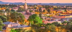 The photo appears to be a cityscape of Santa Fe, New Mexico, where upcoming music programs for children will be held.