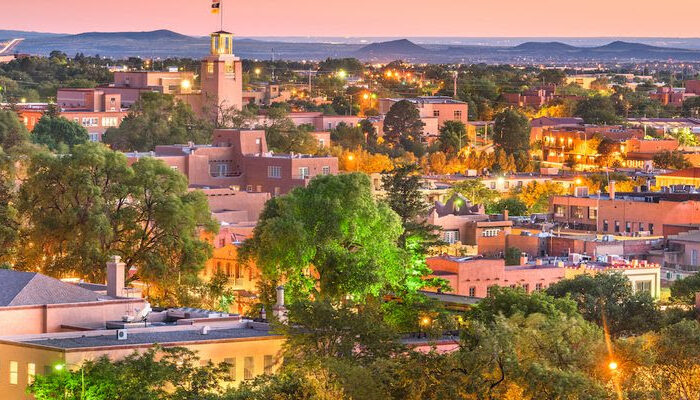 The photo appears to be a cityscape of Santa Fe, New Mexico, where upcoming music programs for children will be held.