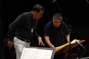 Caption: Xiaogang Ye (L) working with Yang Yang (R) in the studio recording of Song of Farewell